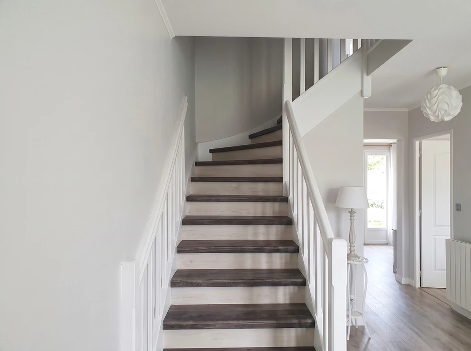Couloir d'appartement rénové, lumineux, avec parquet stratifié chêne clair