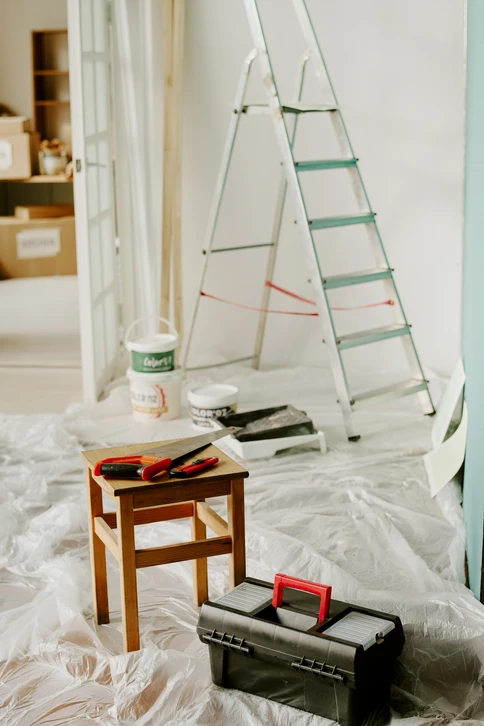 Chambre vide, lumineuse, murs blancs, parquet stratifié ton chêne foncé